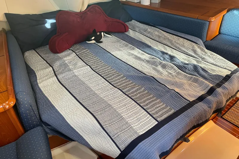 "dragonfly" Yacht Photos Pics Cozy cabin bed in 2003 Jeanneau Sun Odyssey 43 DS yacht with striped bedding.