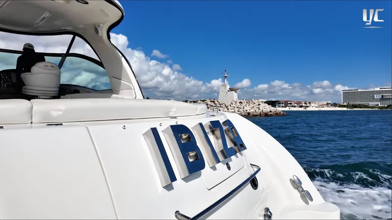  Yacht Photos Pics 2006 Sea Ray 52 Sundancer yacht named "IBIZA" cruising near a coastal lighthouse.