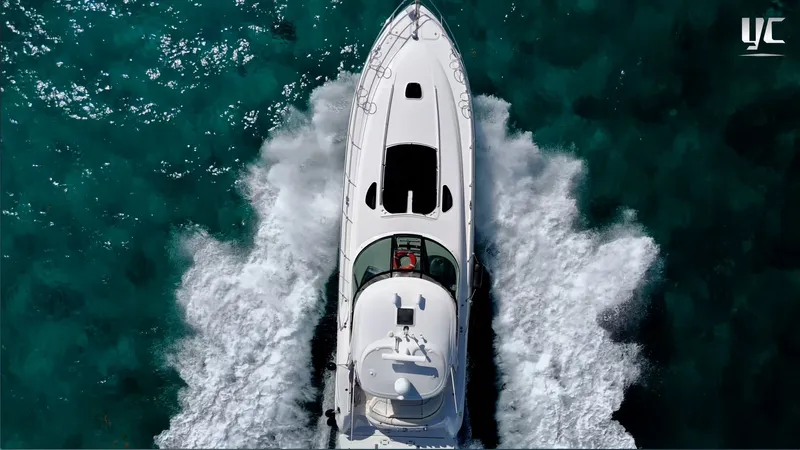  Yacht Photos Pics Aerial view of 2006 Sea Ray 52 Sundancer yacht cruising on clear turquoise water.