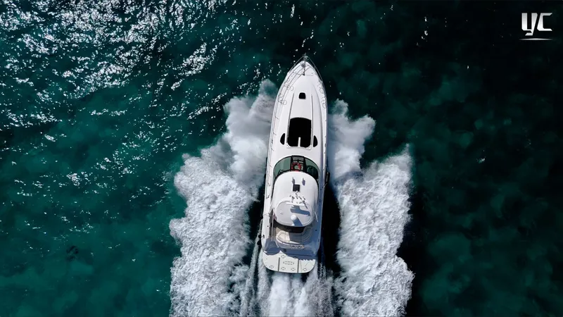  Yacht Photos Pics Aerial view of 2006 Sea Ray 52 Sundancer yacht cruising on clear blue water.