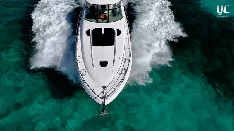  Yacht Photos Pics Aerial view of 2006 Sea Ray 52 Sundancer yacht cruising on clear turquoise water.