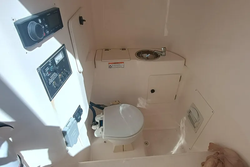 S28-117 Brokerage Joe Yacht Photos Pics 2010 Pursuit S 280 Sport boat interior with toilet and control panel.