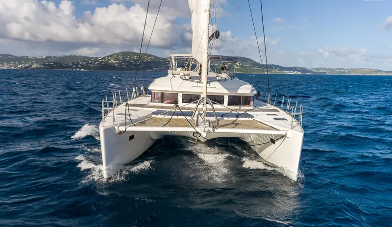  Yacht Photos Pics 2014 Lagoon 620 catamaran sailing on open sea with scenic island backdrop.