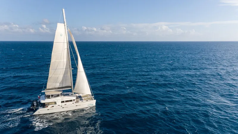  Yacht Photos Pics Sailing catamaran Lagoon 620, 2014 model, cruising on open ocean under clear skies.