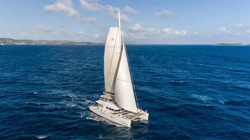  Yacht Photos Pics Sailing catamaran Lagoon 620, 2014 model, cruising on open ocean under clear skies.