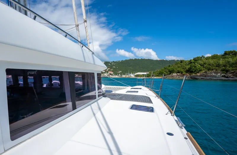  Yacht Photos Pics Lagoon 620 yacht sailing in clear blue waters, 2014 model, with scenic coastal backdrop.