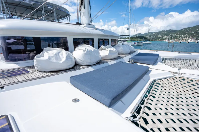  Yacht Photos Pics Luxurious 2014 Lagoon 620 catamaran deck with bean bags and sun loungers, docked in scenic marina.