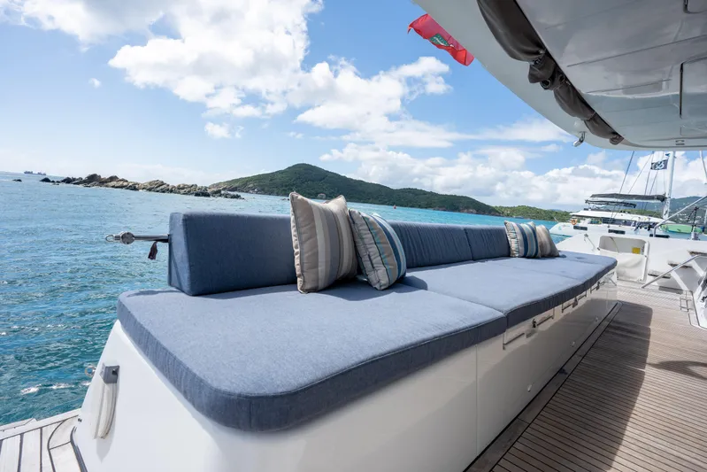  Yacht Photos Pics Luxurious Lagoon 620 yacht deck with blue seating, ocean view, and scenic island backdrop.