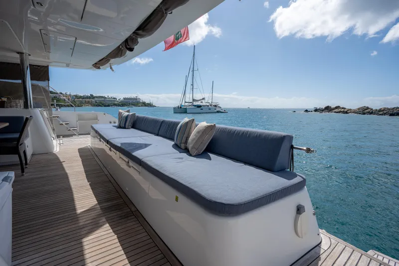  Yacht Photos Pics Luxurious Lagoon 620 yacht deck with seating, overlooking serene ocean and distant sailboat.