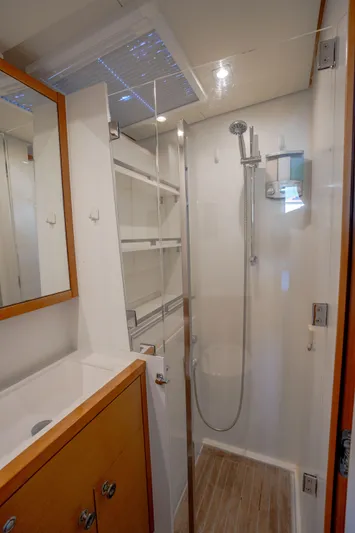  Yacht Photos Pics Compact bathroom in a 2014 Lagoon 620 yacht with modern shower and wooden cabinetry.