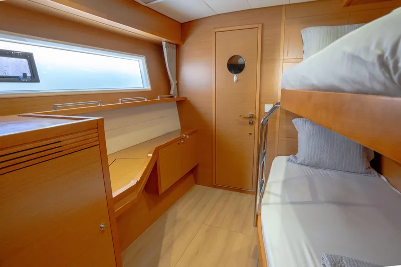  Yacht Photos Pics Interior of 2014 Lagoon 620 yacht with wooden bunk beds and window.