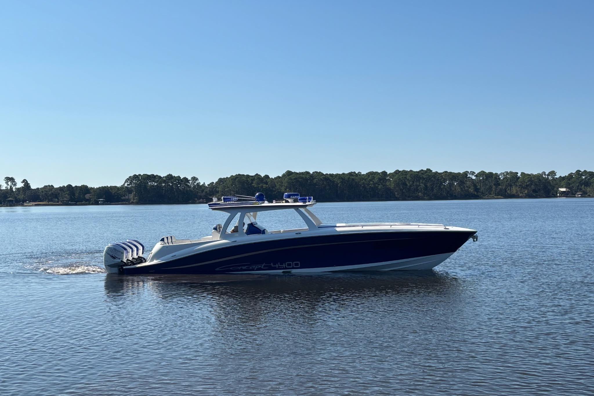 2019 Concept 44' Cuddy Cabin boat cruising on a calm lake under clear blue skies.