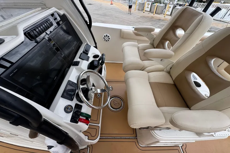  Yacht Photos Pics 2015 Sailfish 320 CC boat cockpit with dual beige captain chairs and modern control panel.
