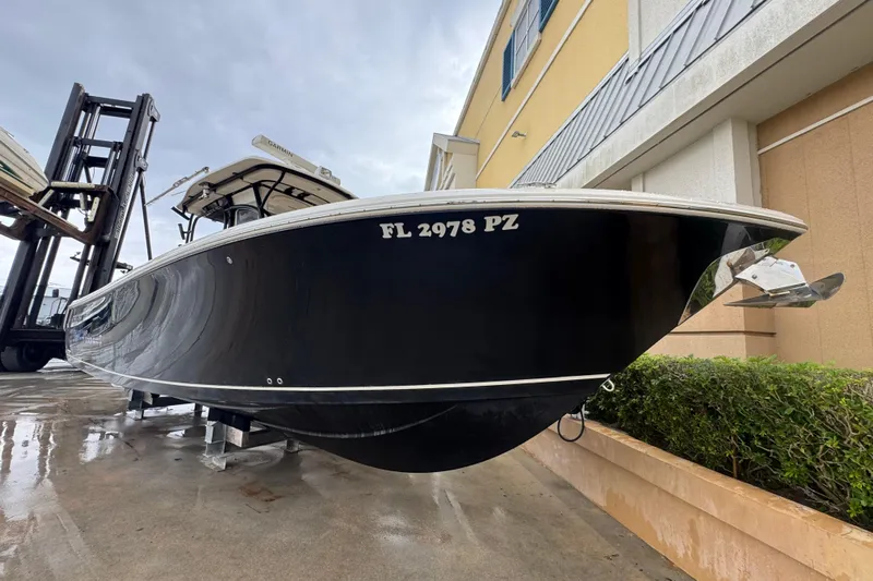 Yacht Photos Pics 2015 Sailfish 320 CC boat on display, black hull, docked near a building.