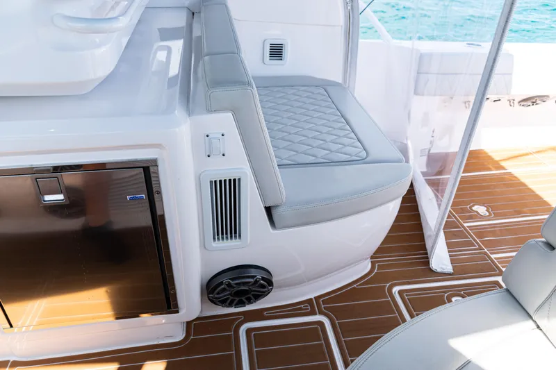  Yacht Photos Pics Interior of 2018 Intrepid 438 Evolution yacht with cushioned seating and wood-patterned flooring.