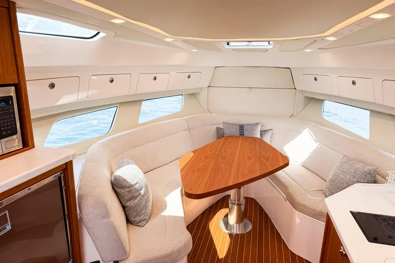  Yacht Photos Pics Luxurious interior of 2018 Intrepid 438 Evolution yacht with elegant seating and wooden table.