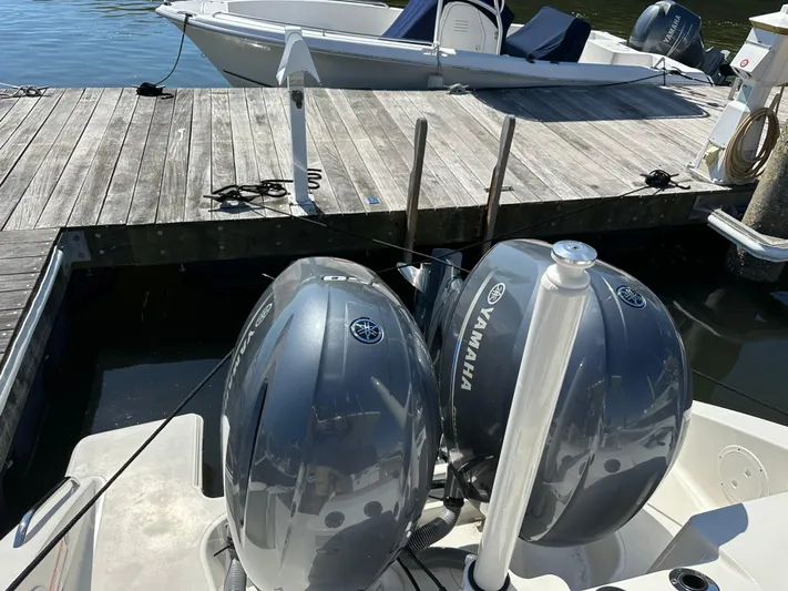  Yacht Photos Pics 2024 Pursuit S 268 boat with twin Yamaha engines docked at a wooden pier.
