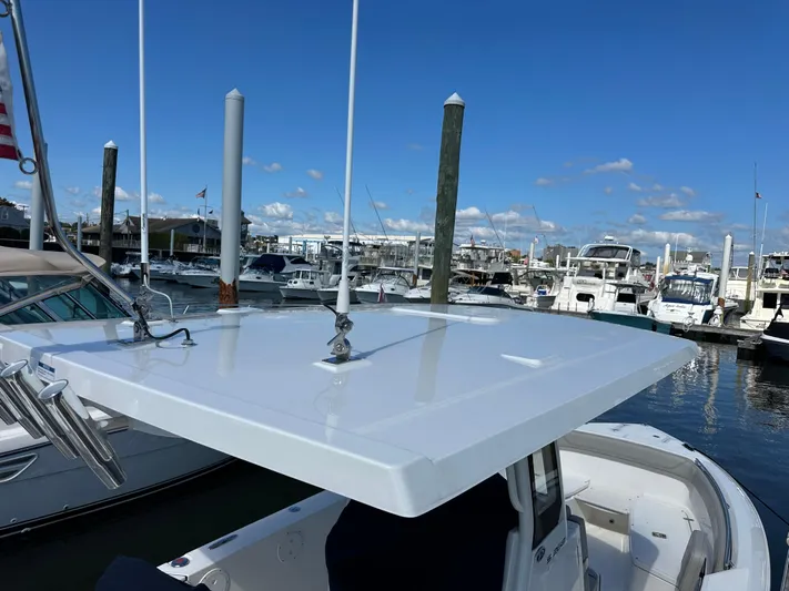  Yacht Photos Pics 2024 Pursuit S 268 boat docked at a marina under a clear blue sky.
