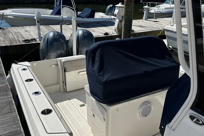  Yacht Photos Pics 2024 Pursuit S 268 boat interior with covered seating and dual engines at dock.