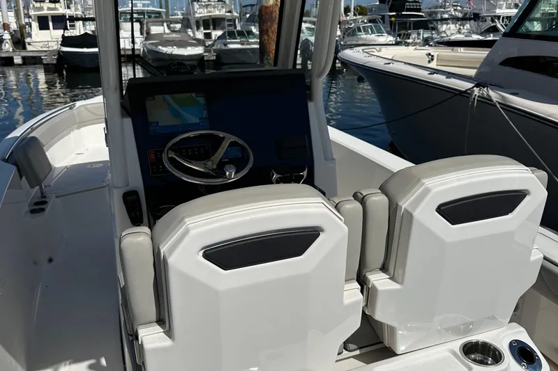  Yacht Photos Pics 2024 Pursuit S 268 boat interior with helm and seating at marina.