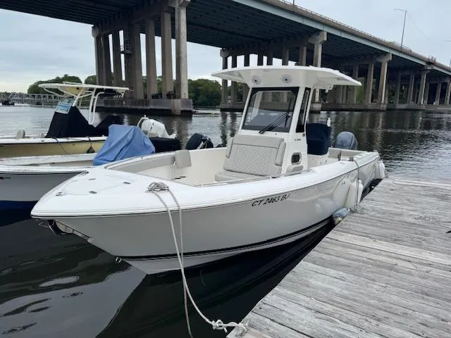  Yacht Photos Pics 2024 Pursuit S 268 boat docked under a bridge on a calm river.
