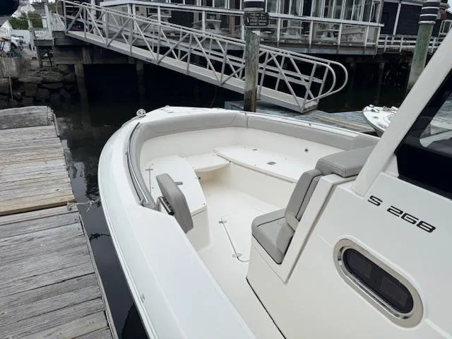  Yacht Photos Pics 2024 Pursuit S 268 boat docked, showcasing spacious seating and sleek design.
