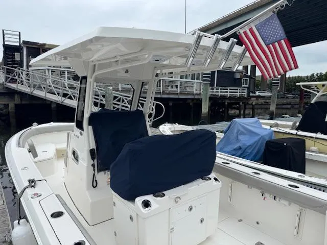  Yacht Photos Pics 2024 Pursuit S 268 boat docked, featuring covered seating and an American flag.