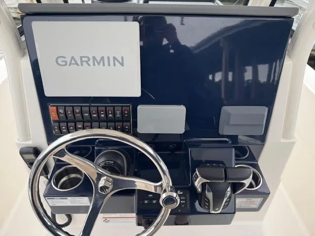  Yacht Photos Pics 2024 Pursuit S 268 boat dashboard with Garmin navigation system and steering wheel.