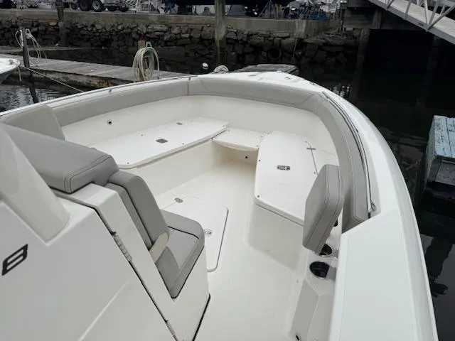  Yacht Photos Pics 2024 Pursuit S 268 boat interior with seating and storage, docked at a marina.