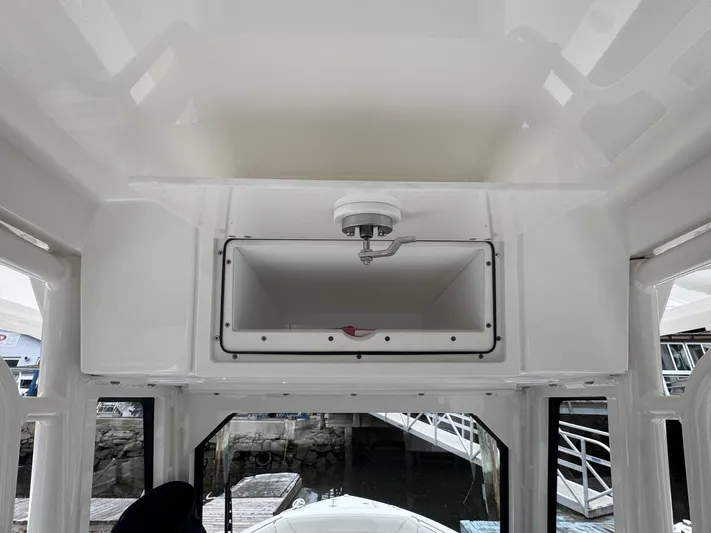  Yacht Photos Pics 2024 Pursuit S 268 boat interior with storage compartment and dock view.