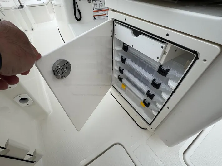  Yacht Photos Pics 2024 Pursuit S 268 boat storage compartment with organized tackle boxes.
