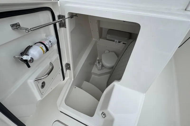  Yacht Photos Pics 2024 Pursuit S 268 boat interior with compact marine toilet and safety equipment.