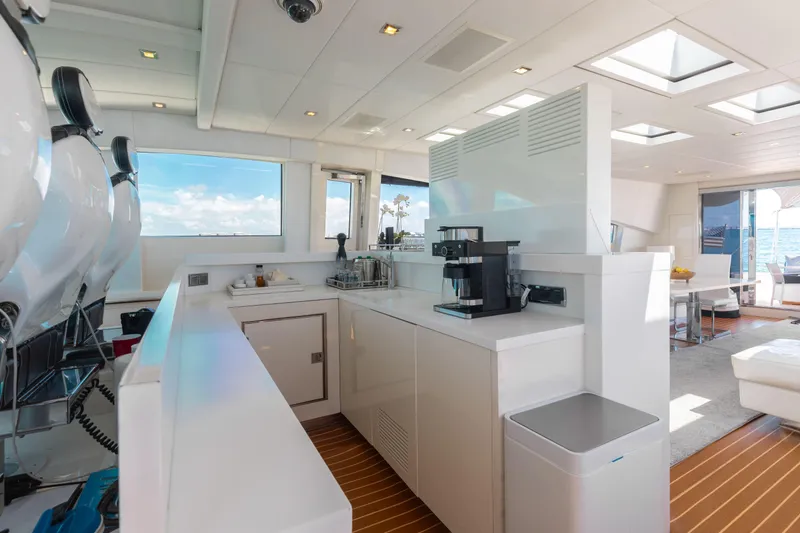 Venture Yacht Photos Pics Luxurious yacht interior with modern kitchen, featuring sleek white cabinetry and ocean views.