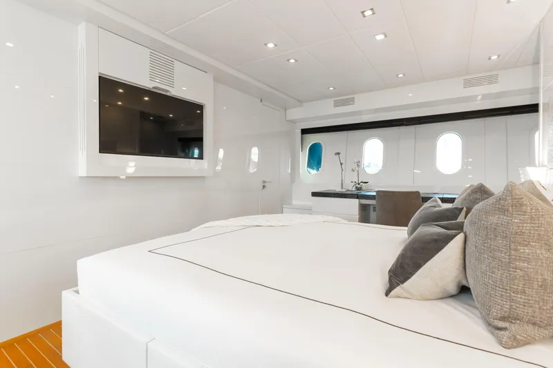 Venture Yacht Photos Pics Luxurious yacht bedroom interior with modern decor, featuring a large bed and wall-mounted TV.