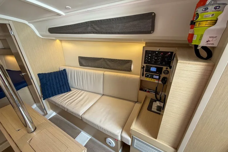 Coastal Distancing Yacht Photos Pics Interior of 2021 Beneteau Oceanis 30.1 yacht with beige seating and control panel.