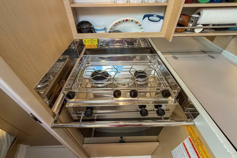 Coastal Distancing Yacht Photos Pics Compact kitchen with stove in 2021 Beneteau Oceanis 30.1 yacht interior.