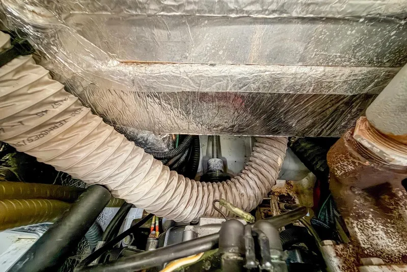 Coastal Distancing Yacht Photos Pics Engine compartment of 2021 Beneteau Oceanis 30.1 sailboat, showing hoses and mechanical components.