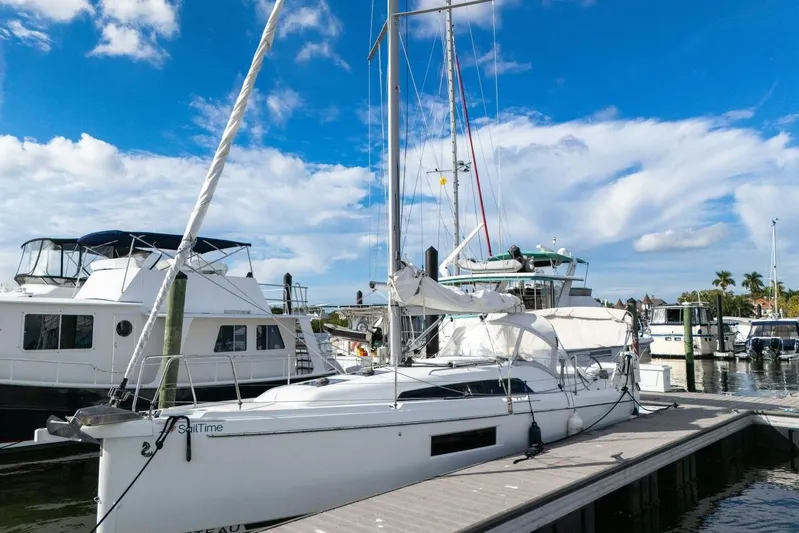 Coastal Distancing Yacht Photos Pics 2021 Beneteau Oceanis 30.1 sailboat docked at a marina under a blue sky.