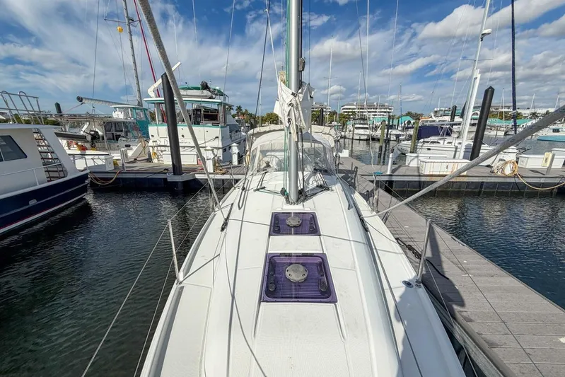 Coastal Distancing Yacht Photos Pics 2021 Beneteau Oceanis 30.1 sailboat docked in a marina under a blue sky.