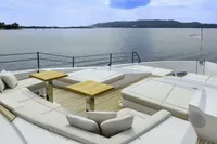 Luxurious 2023 Custom Line CL106 yacht deck with elegant seating and scenic ocean view.