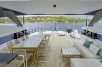 Luxurious 2023 Custom Line CL106 yacht deck with elegant seating and scenic ocean view.