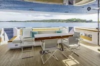 Luxurious 2023 Custom Line CL106 yacht deck with seating, table, and ocean view.