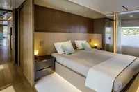 Luxurious 2023 Custom Line CL106 yacht bedroom with modern design and scenic window view.