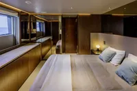 Luxurious bedroom interior on 2023 Custom Line CL106 yacht, featuring elegant wood finishes and ocean view.