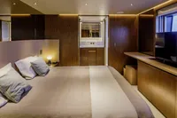 Luxurious bedroom in 2023 Custom Line CL106 yacht with modern wood finishes and ambient lighting.