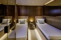 Luxurious twin cabin interior of 2023 Custom Line CL106 yacht, featuring elegant wood paneling.