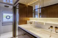 Luxurious yacht bathroom with dual sinks, marble countertop, and wooden cabinetry, Custom Line CL106, 2023.