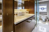 Luxurious yacht bathroom with wooden cabinetry, modern fixtures, and a porthole window, Custom Line CL106.
