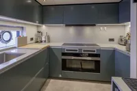 Modern kitchen interior in 2023 Custom Line CL106 yacht, featuring sleek cabinetry and appliances.