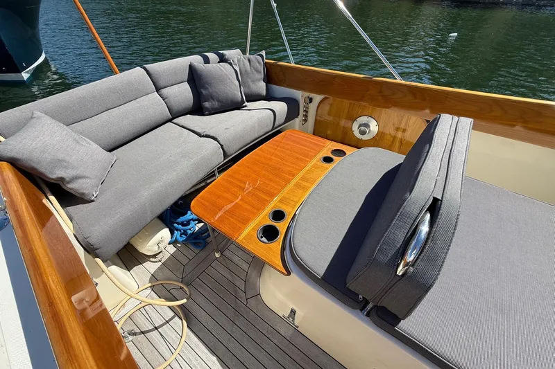 Timothy E Yacht Photos Pics 2001 Hinckley Classic Picnic Boat interior with gray seating and wooden table on water.